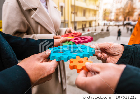 Business team work together and combine pieces of gears. Partnership and integration concept 107013222