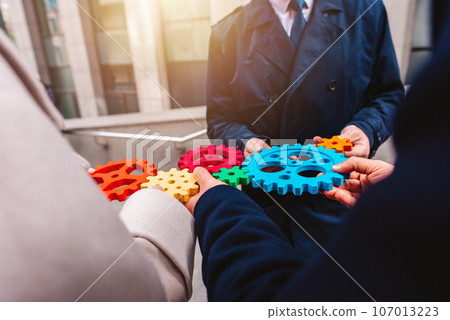 Business team work together and combine pieces of gears. Partnership and integration concept 107013223