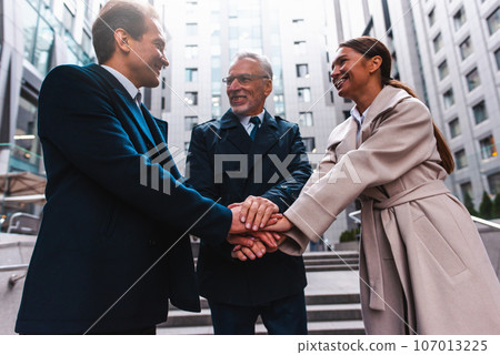 Business people putting their hands together as teamwork and partner Business people putting their hands together as teamwork and partner 107013225