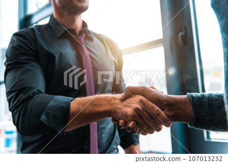 Handshaking of business people in office as concept of teamwork and partnership 107013232
