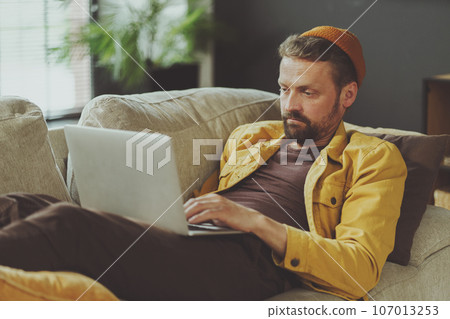 Weary man takes well-deserved break in office chair, reclining and unwinding after long and exhausting workday. Finding solace and relief in corporate world, where moments of rest become cherished 107013253