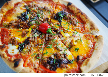 Delicious pizza on thin dough on the table. 107013629