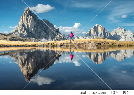 Walking woman and mountains reflected in lake at sunset in autum 107013944