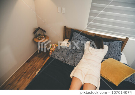 young woman lying in bed young woman lying in bed 107014074