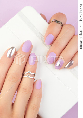 Close up womans hands with matte lavender and silver nails. Beauty treatment Close up womans hands with matte lavender and silver nails. Beauty treatment 107014273