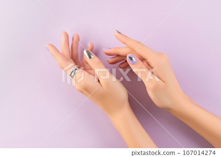 Womans hands with matte lavender and silver nails. Beauty treatment Womans hands with matte lavender and silver nails. Beauty treatment 107014274