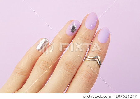Close up womans hand with matte lavender and silver nails. Beauty treatment Close up womans hand with matte lavender and silver nails. Beauty treatment 107014277