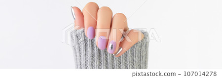 Close up womans hand with matte lavender and silver nails in sweater Close up womans hand with matte lavender and silver nails in sweater 107014278