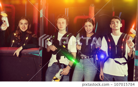 Triumphing team of laser tag winners guys and girls in game room Triumphing team of laser tag winners guys and girls in game room 107015784