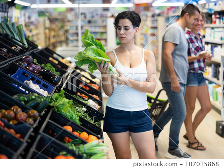 Woman choosing lettuce in supermarket Woman choosing lettuce in supermarket 107015868