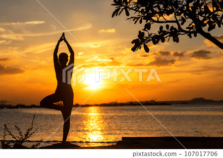 Silhouette lifestyle woman yoga exercise and worm up raise arm before pose for healthy life 107017706
