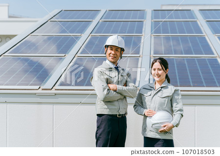 電力公司/電氣承包商穿著工作服的工程師/商務人員站在太陽能發電/太陽能板前 電力公司/電氣承包商穿著工作服的工程師/商務人員站在太陽能發電/太陽能板前 107018503
