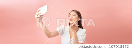 Young Asian girl using smartphone on pink background. Web banner 107018552