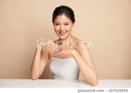 Beautiful young asian woman with clean fresh skin on beige background, Face care, Facial treatment, Cosmetology, beauty and spa, Asian women portrait. 107020650