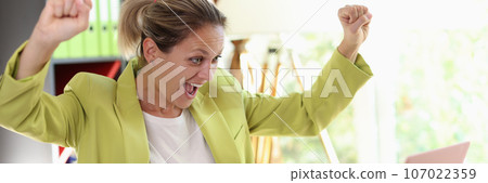 Happy female manager looking at computer screen while sitting at desk. Happy female manager looking at computer screen while sitting at desk. 107022359