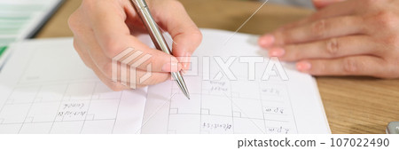 Business woman checks her planner and takes notes in organizer. 107022490