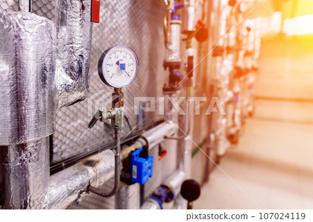 Interior industrial gas boiler with a lot of piping, pumps and valves Interior industrial gas boiler with a lot of piping, pumps and valves 107024119