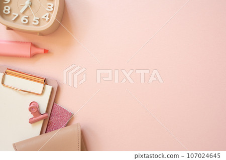 Pink notebook, clipboard, clip, pouch, highlighter, clock on pink desk background. flat lay, top view, copy space. workspace Pink notebook, clipboard, clip, pouch, highlighter, clock on pink desk background. flat lay, top view, copy space. workspace 107024645