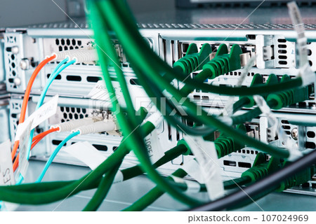 fiber optic cables connected to optic ports, network cables connected to ethernet ports fiber optic cables connected to optic ports, network cables connected to ethernet ports 107024969
