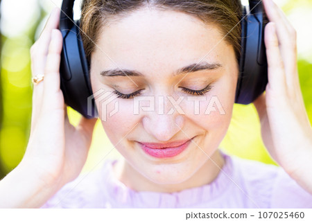 Intense Musical Connection: Young Woman in Serene Nature 107025460
