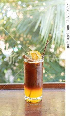 Iced americano coffee and orange juice in a cafe. 107025977