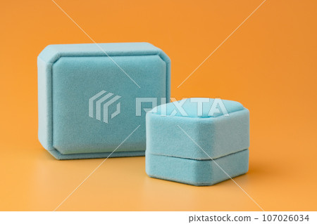 Blue jewelry box on yellow background close up Blue jewelry box on yellow background close up 107026034