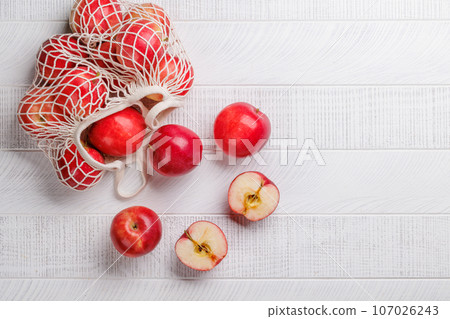 Mesh bag with fresh red apples Mesh bag with fresh red apples 107026243
