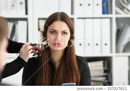 Beautiful brunette businesswoman hold in arm phone Beautiful brunette businesswoman hold in arm phone 107027621