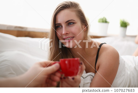blond woman have cup of tea coffee early morning in her bed blond woman have cup of tea coffee early morning in her bed 107027683