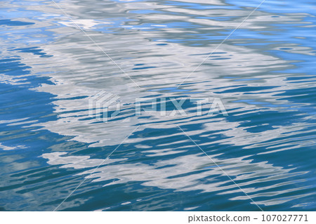 White clouds reflecting on the water surface with small ripples 107027771