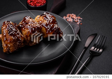 Delicious juicy fried chicken with sweet and sour teriyaki sauce and sesame seeds Delicious juicy fried chicken with sweet and sour teriyaki sauce and sesame seeds 107029191