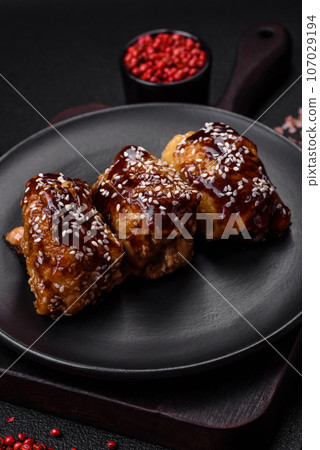 Delicious juicy fried chicken with sweet and sour teriyaki sauce and sesame seeds Delicious juicy fried chicken with sweet and sour teriyaki sauce and sesame seeds 107029194