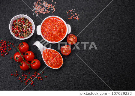 Delicious hot spicy red sauce with salt and spices in a ceramic bowl 107029223