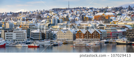 Snowy roofs, embankment near the port and fishing ships, Sunny winter day. 107029413