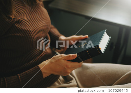 Hands together in prayer to God along with the bible In the Christian concept and religion, woman pray in the Bible 107029445