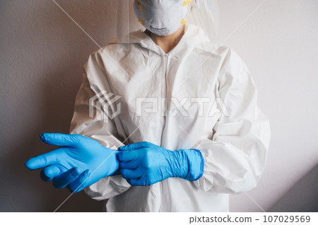 Healthcare worker wearing safety glove and PPE suit for working in hospital during Covid-19 pandemic. PPE is equipment that will protect the user against health or safety risks at work. Healthcare worker wearing safety glove and PPE suit for working in hospital during Covid-19 pandemic. PPE is equipment that will protect the user against health or safety risks at work. 107029569