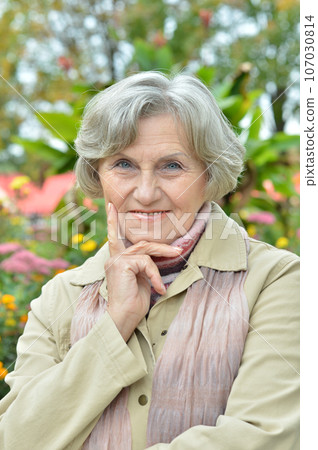 Senior woman walking in the park in autumn Senior woman walking in the park in autumn 107030814