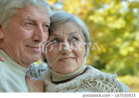 Nice elderly couple in a autumn park Nice elderly couple in a autumn park 107030815