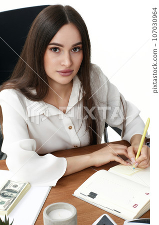 beautiful businesswoman in white shirt taking notes 107030964