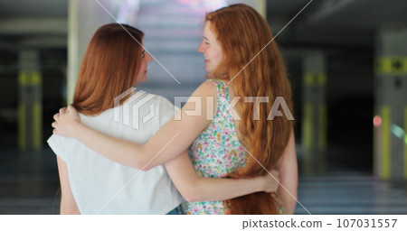 Two lesbian woman lgbt couple girlfriends hugging, holding hands outdoors. Concept LGBT happiness freedom love homosexual couple. 107031557