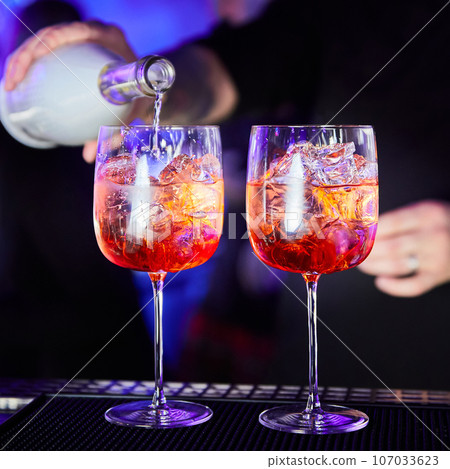 Bartender prepares alcoholic cocktail on bar counter 107033623