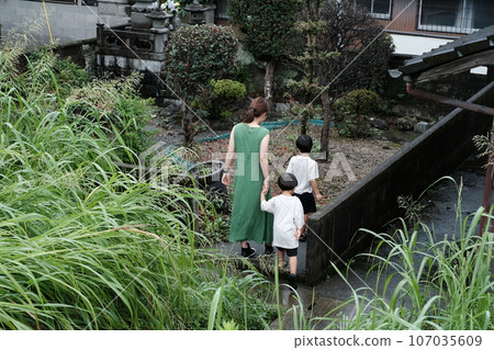 Parent and child visiting the grave Parent and child visiting the grave 107035609