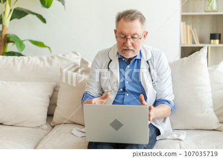 Senior man doctor with laptop talk on video call have consultation with patient. Professional senior mature healthcare expert examining patient online. Medicine healthcare medical checkup 107035719