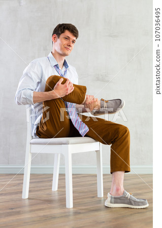 Young guy office worker doing exercises on chair Young guy office worker doing exercises on chair 107036495