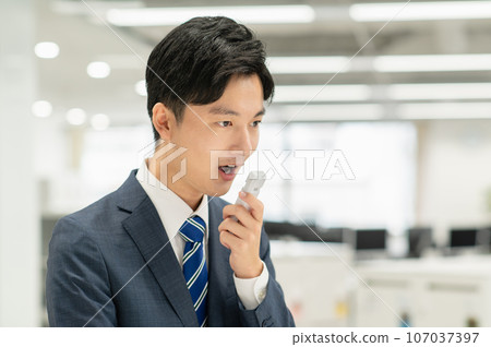 Young businessman checking alcohol in office Young businessman checking alcohol in office 107037397