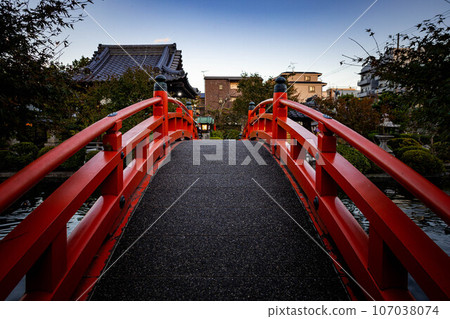 Autumn at Shinsenen, the bright red Hosei Bridge over the Hosei Pond, a moment at dusk 107038074