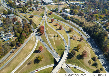 American freeway intersection in Asheville, North Carolina with fast driving cars and trucks in autumnal season. View from above of USA transportation infrastructure American freeway intersection in Asheville, North Carolina with fast driving cars and trucks in autumnal season. View from above of USA transportation infrastructure 107040501
