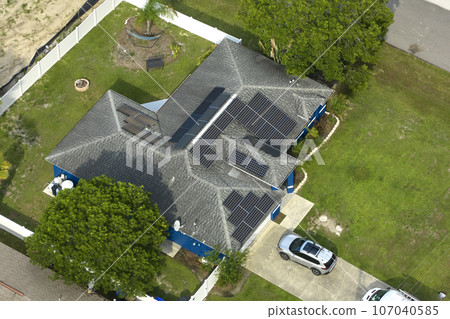 Aerial view of typical contemporary american private house with roof top covered with asphalt shingles and green lawn on yard 107040585