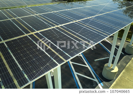 Aerial view of solar panels installed as shade roof over parking lot for parked cars for effective generation of clean electricity. Photovoltaic technology integrated in urban infrastructure 107040665