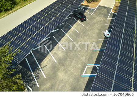 Aerial view of solar panels installed as shade roof over parking lot for parked cars for effective generation of clean electricity. Photovoltaic technology integrated in urban infrastructure 107040666